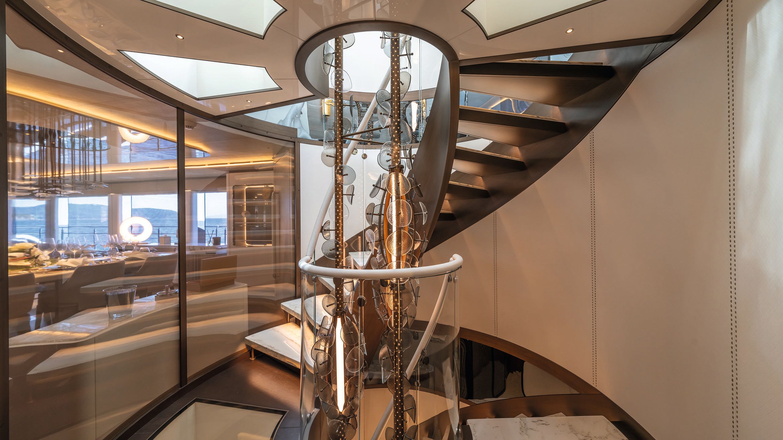 Wide view from the centre of the staircase showing the chandelier snaking down the centre