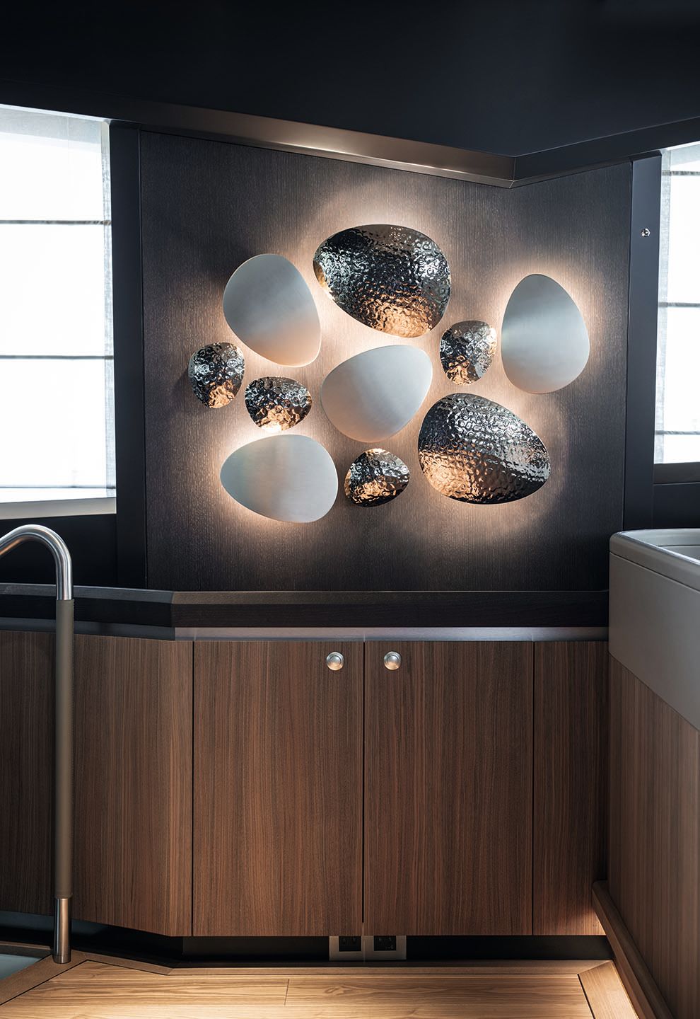 Walnut cabinet with abstract white and chrome wall light