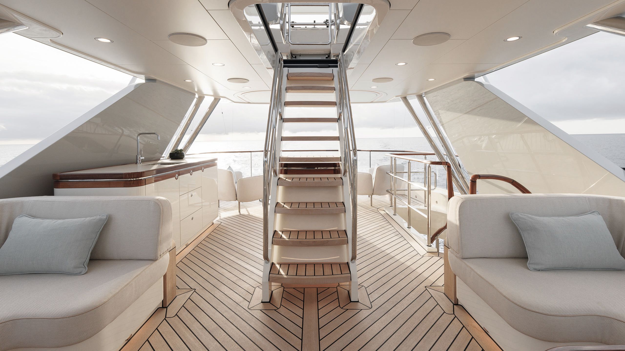 Steps leading to the flybridge, the deck and wood is a light finish and the rails are chrome