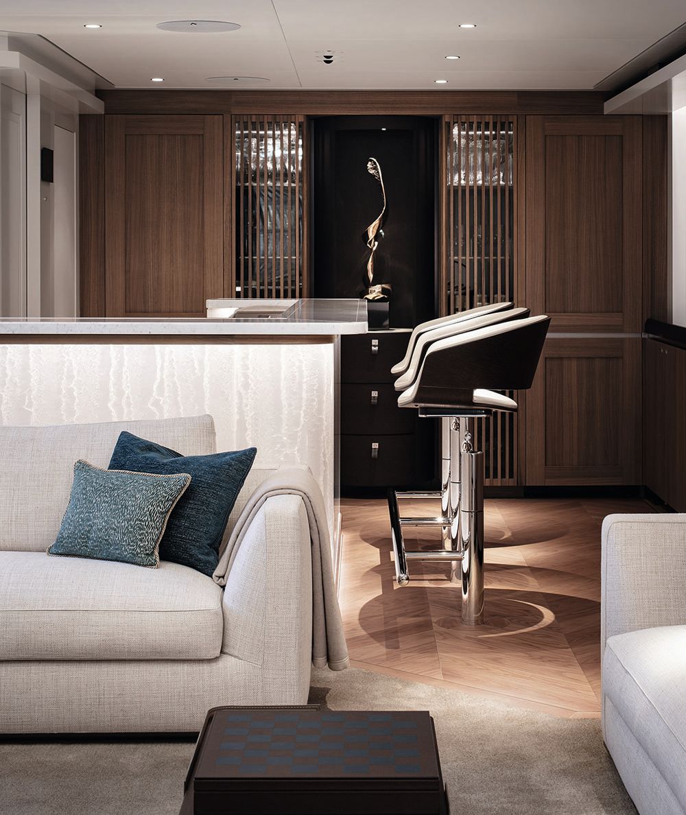 Side view of the bar, which has high stools. In the background is the walnut wine cabinet which has a ribbed front