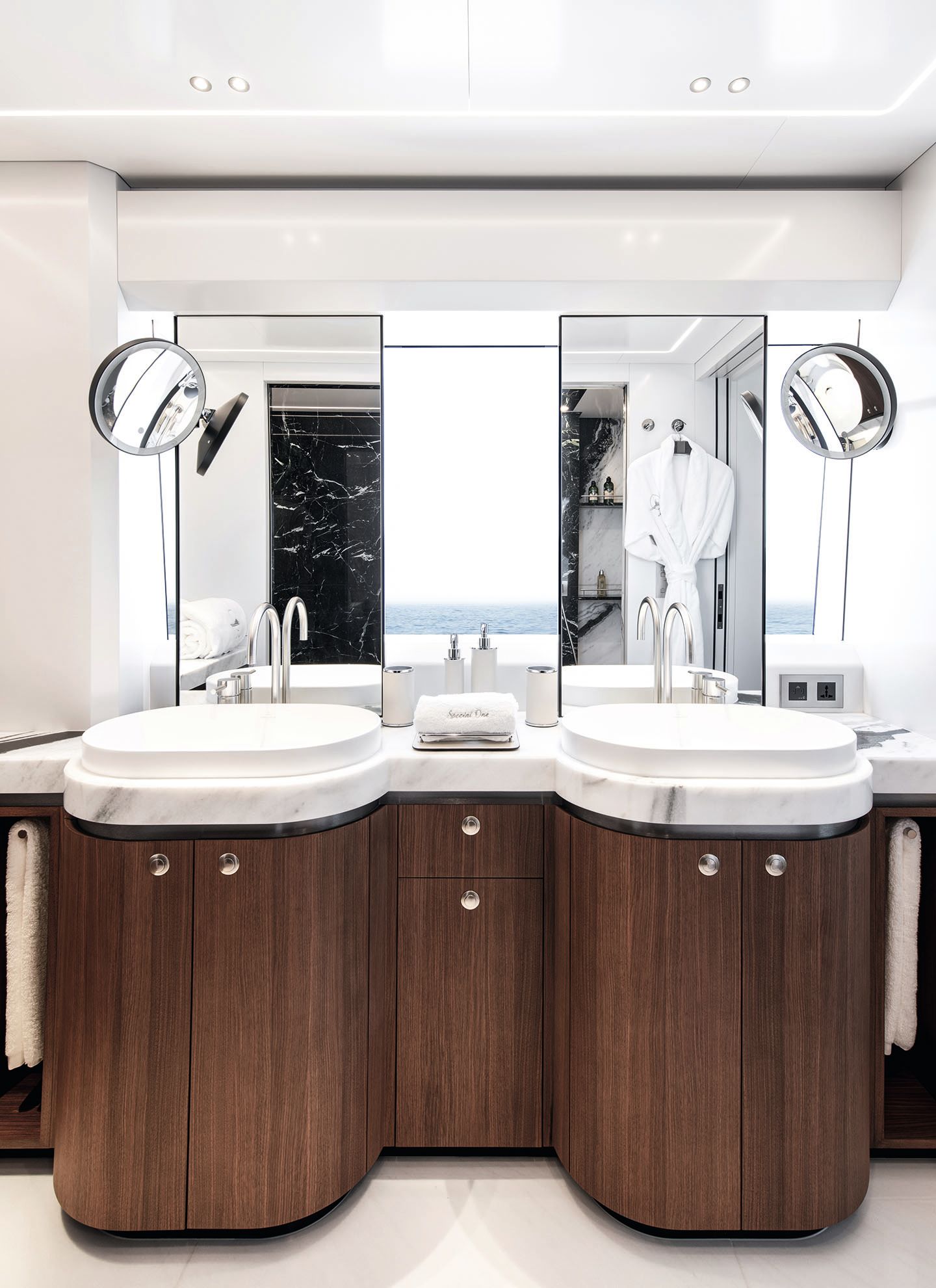 Front view of the bathroom, which has double sinks in white marble with chrome taps