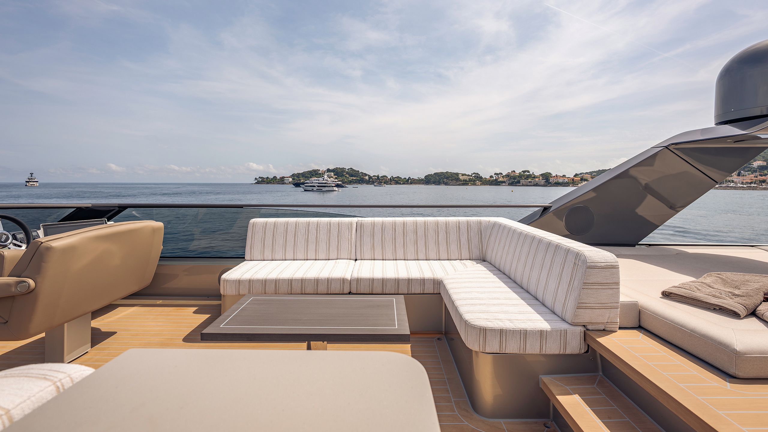 L-shaped white banquette-style sofa with thin stripes on an outdoor deck
