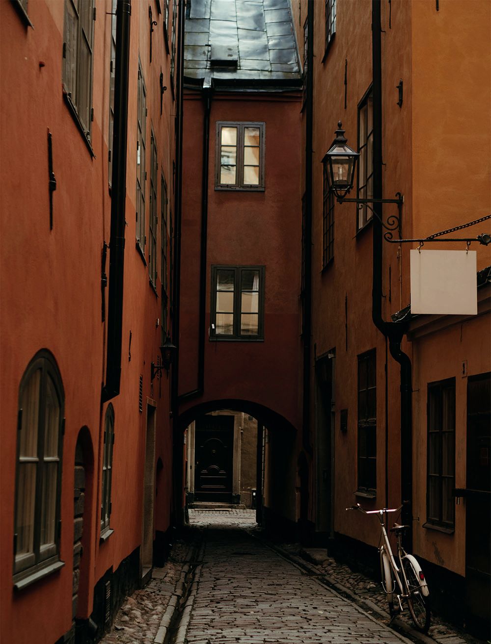 Looking down a side street in Visby; the buildings are dark orange and the street is cobbled
