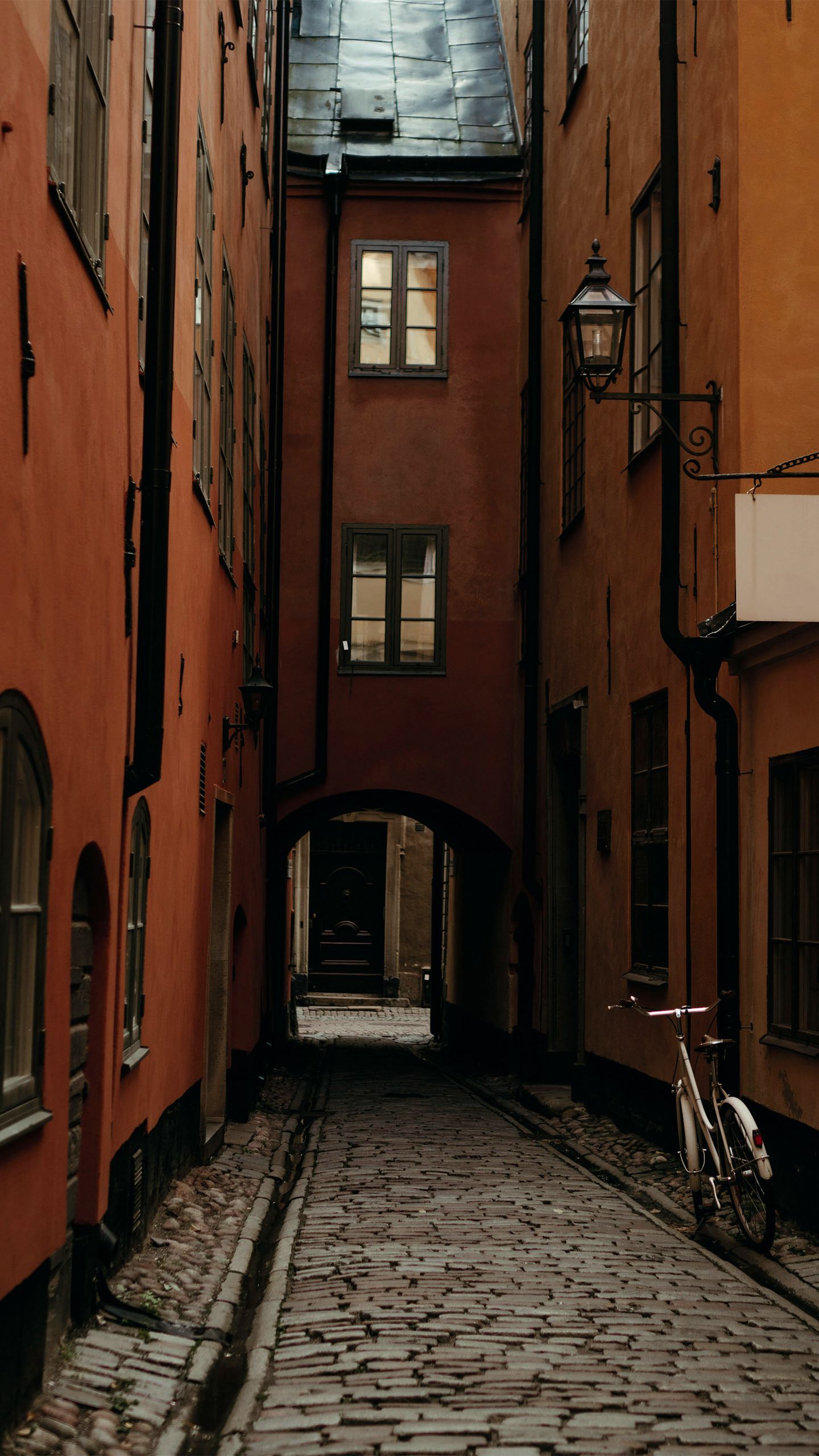 Looking down a side street in Visby; the buildings are dark orange and the street is cobbled