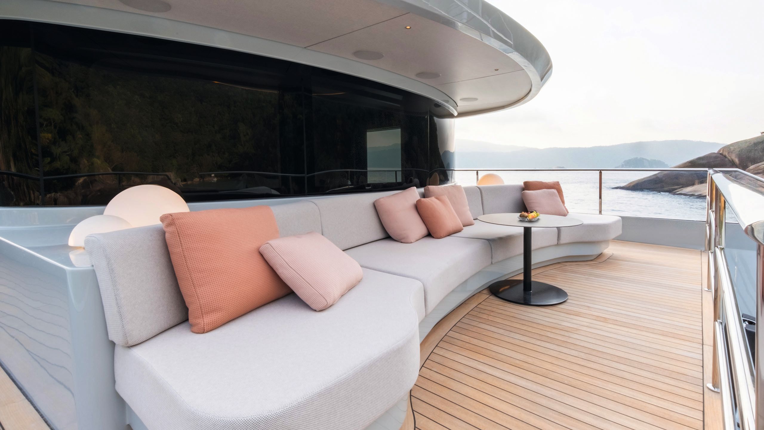 Another curved outdoor sofa in taupe with pink cushions