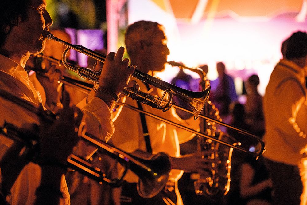 Close-up of a band playing brass instruments in orange light